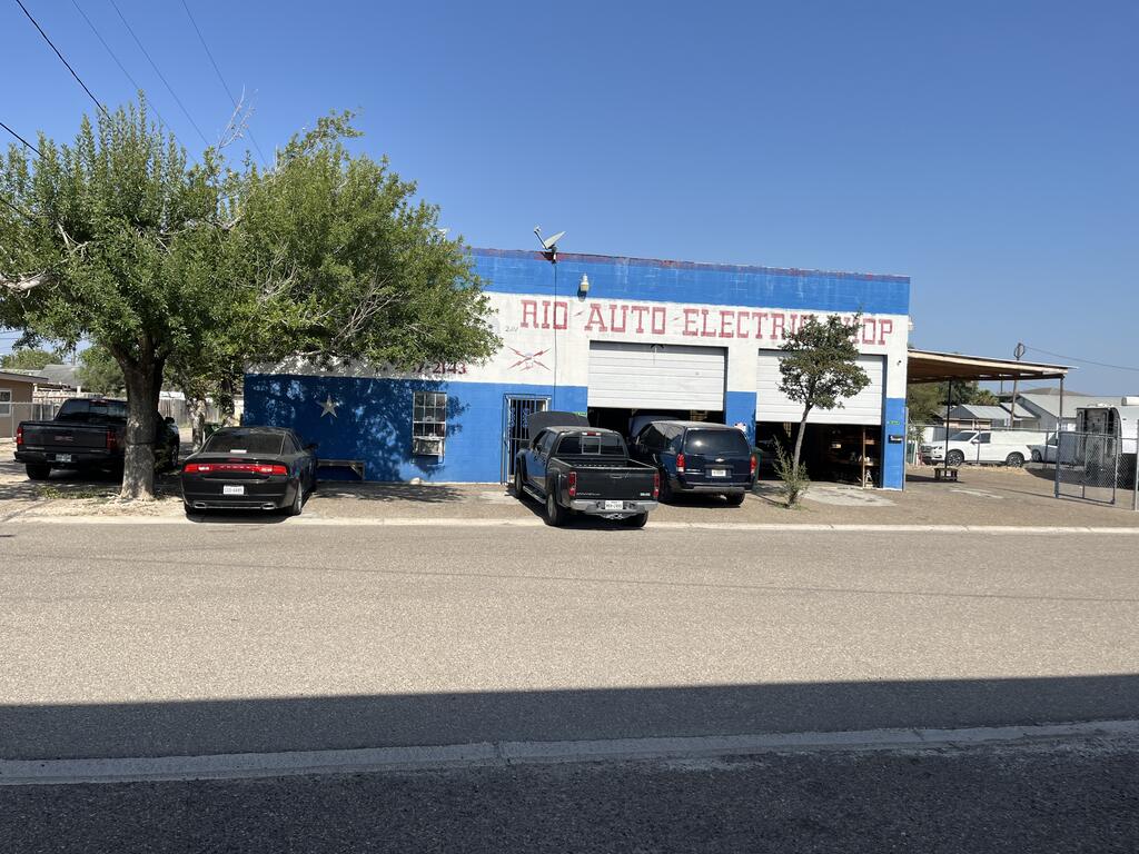 Front of the commercial building at 400 W Main St in downtown Rio Grande City, a blue-and-white shop building with two overhead doors facing Main Street